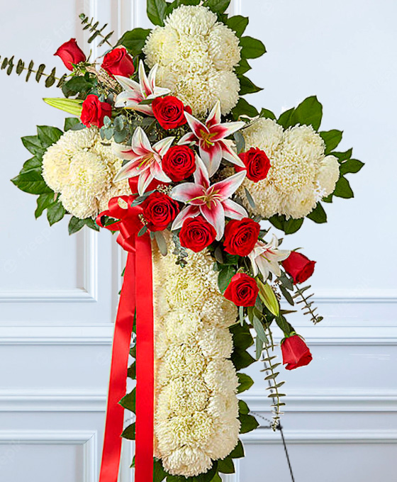 Cruz funeraria blanca con rosas rojas en Gijón