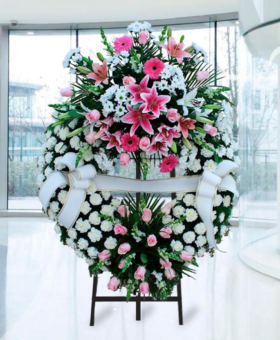 Corona funeraria de clavel de flores rosas y blancas